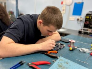 Greasley - Supporting the future of the next generation Supporting the future of the next generation at Greasley Electronics. Sam repairing a circuit board.